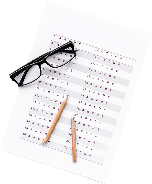 Feuille de réponse à un examen avec une paire de lunette et un crayon cassé dessus.